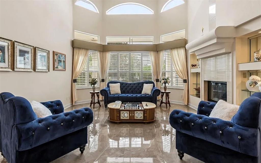 A living room features blue tufted furniture, a central coffee table, and a large fireplace — 1036 GOLF VALLEY DRIVE, APOPKA, FL