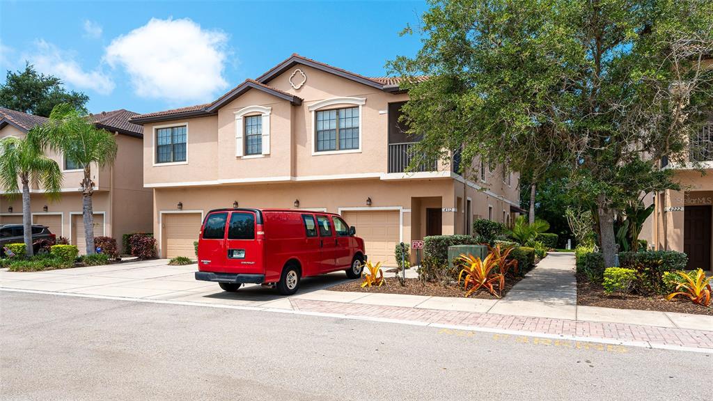 A red van is parked in front of a two-story tan stucco townhouse — 4316 VIA PIEDRA CIRCLE UNIT 5-204, SARASOTA, FL