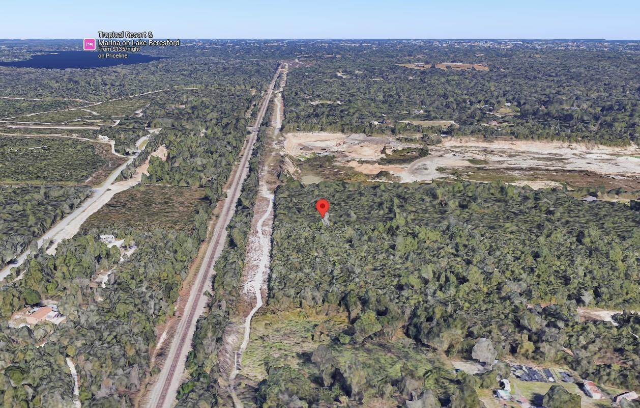 This is an aerial view of a wooded lot next to railroad tracks and a quarry — 0 Riegel Paper, FL 32763, FL