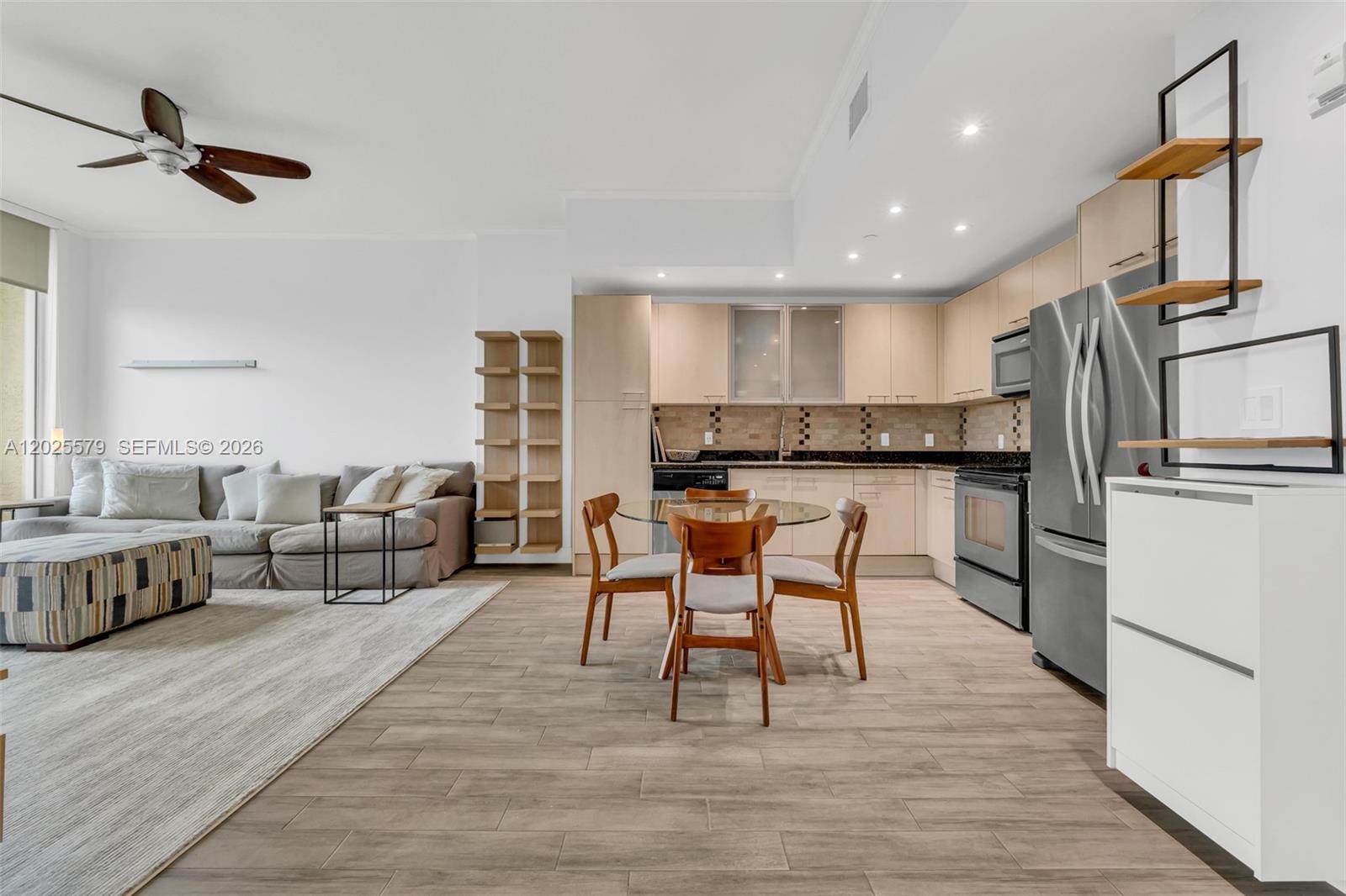 An open-concept living and dining area features a modern kitchen with light wood cabinetry — 1350 NW 8th Ct # 207, Miami FL 33136, MIAMI, FL