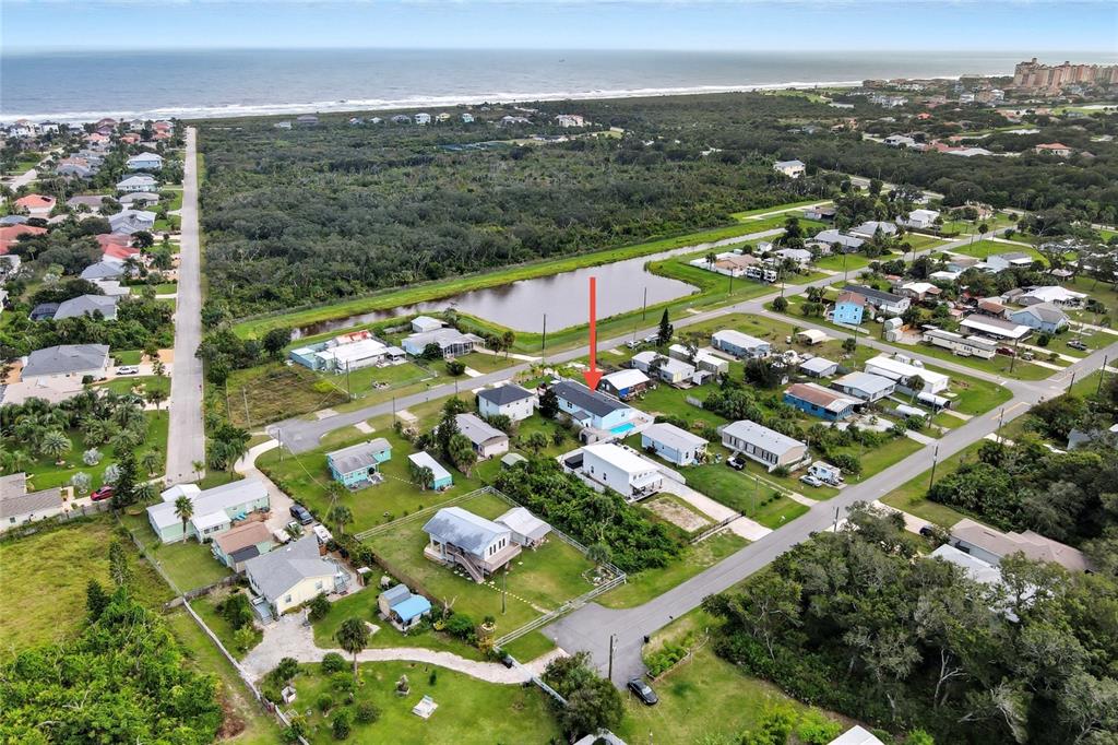 An aerial view shows a residential neighborhood near the coast with a marked house — 34 1ST AVENUE, PALM COAST, FL