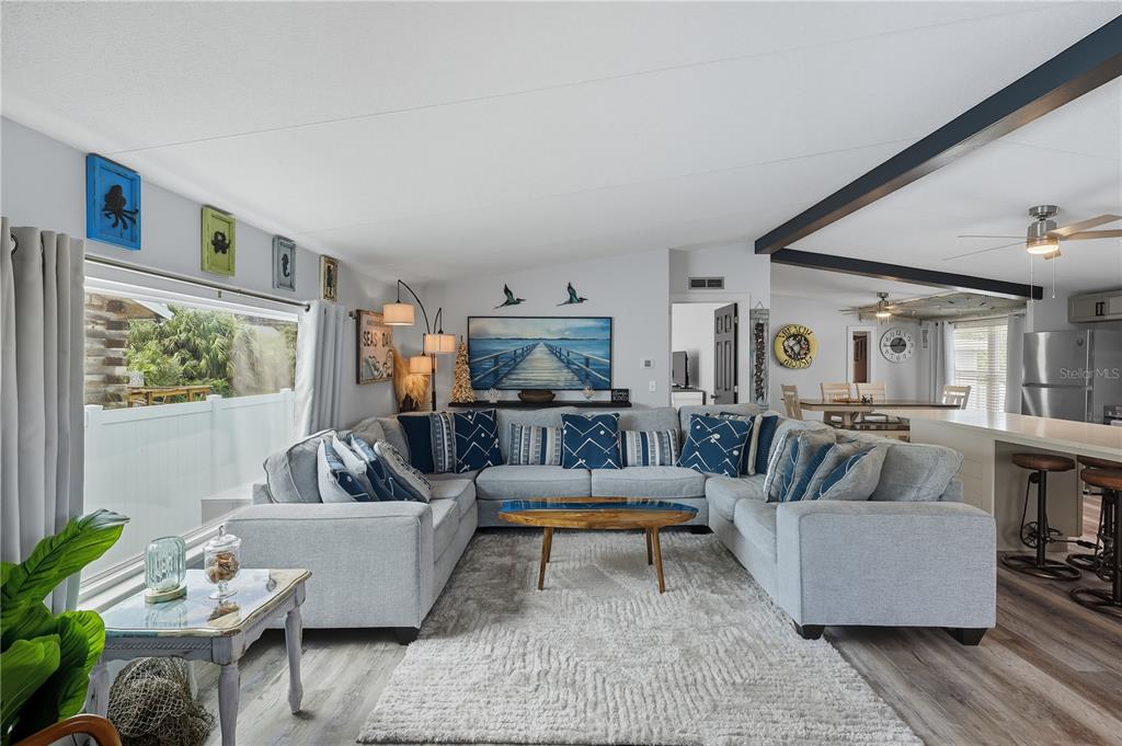 A living room features a large gray sectional sofa, a coffee table, and coastal decor — 34 1ST AVENUE, PALM COAST, FL