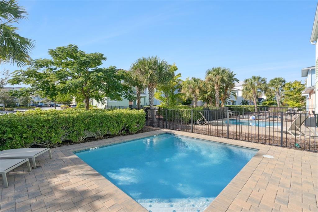 A small rectangular swimming pool sits on a paved patio next to a fenced yard — 8082 KNEE DEEP ROAD, KISSIMMEE, FL