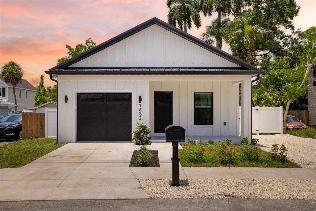 A white single-story house with a black garage door, black trim, and a front porch — 1632 BALLARD PARK DRIVE, BRADENTON, FL