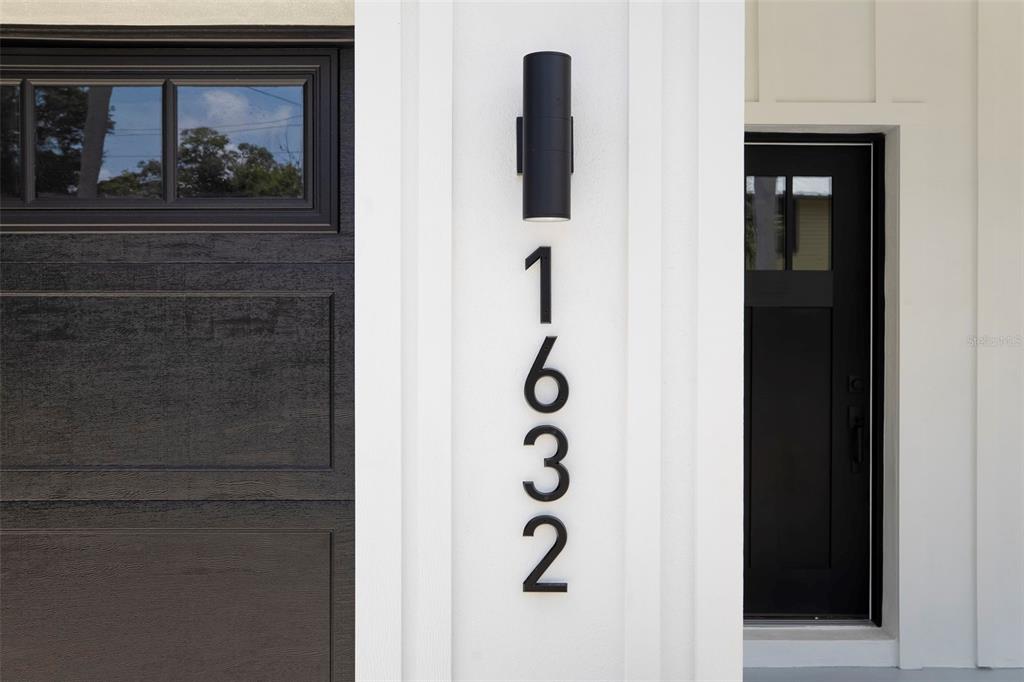 A vertical house number 1632 is mounted on a white pillar beside a black garage door — 1632 BALLARD PARK DRIVE, BRADENTON, FL