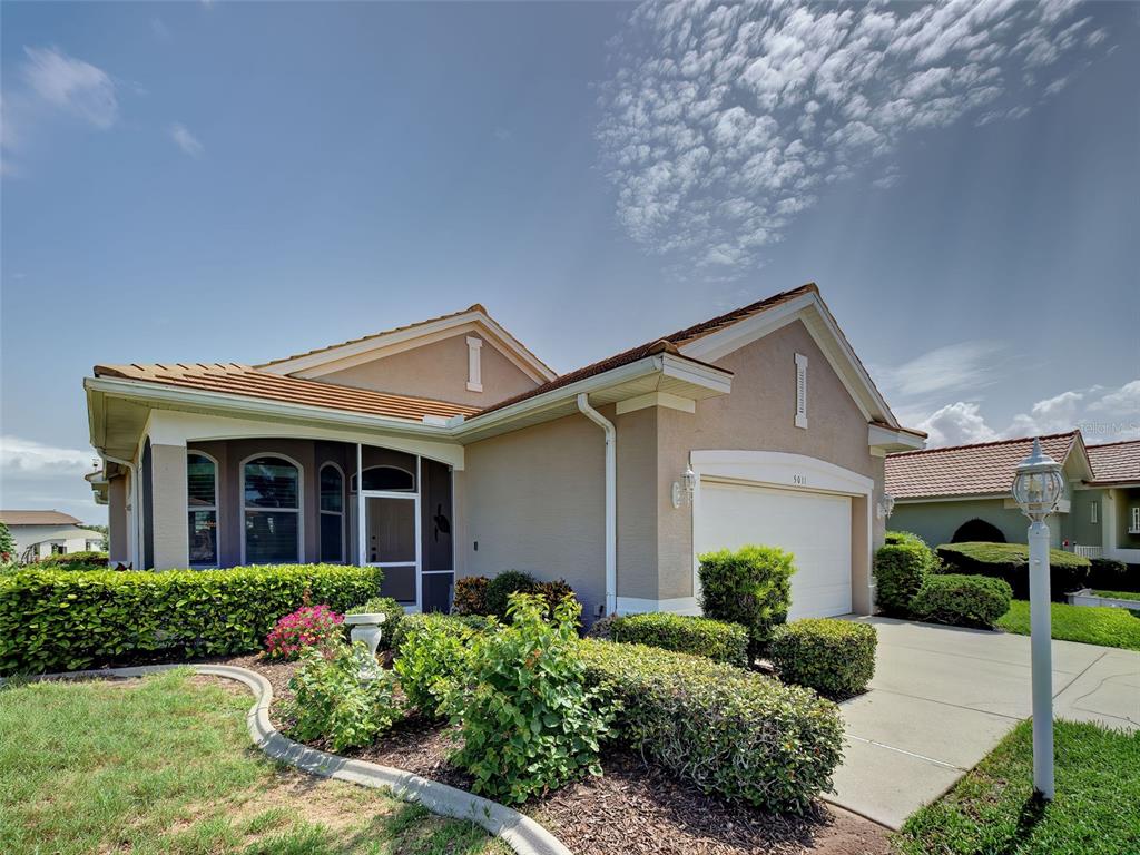 A single-story house with a tan stucco exterior, a tiled roof, and a two-car garage — 5011 SEAGRASS DRIVE, VENICE, FL
