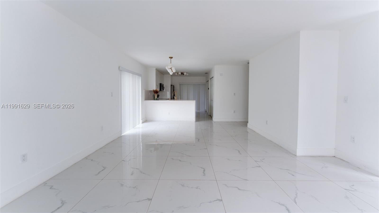 An open-concept living area features white walls and polished marble-look tile flooring — 22226 SW 98th Pl, Cutler Bay FL 33190, CUTLER BAY, FL