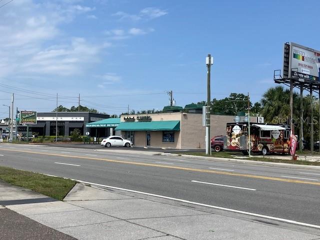 A commercial building with a green awning sits beside a food truck on a street — 3501 / 3519 HENDERSON BOULEVARD, TAMPA, FL