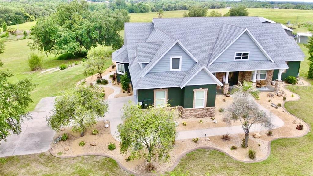 An aerial view shows a two-story house with a gray roof and dark green siding — 32112 JACK RUSSELL COURT, DADE CITY, FL