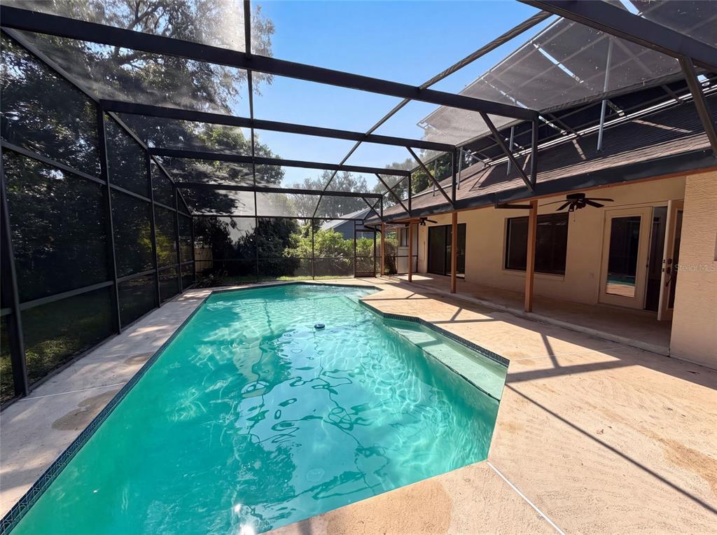 A swimming pool enclosed by a screened lanai next to a house with a patio — 332 SPRUCEWOOD ROAD, LAKE MARY, FL