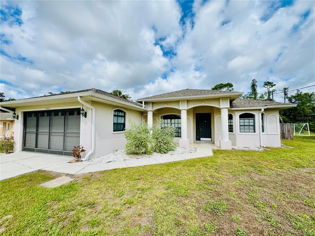 A single-story house with a garage, arched entryway, and light-colored stucco exterior under a cloudy sky — 3309 N CRANBERRY BOULEVARD, NORTH PORT, FL