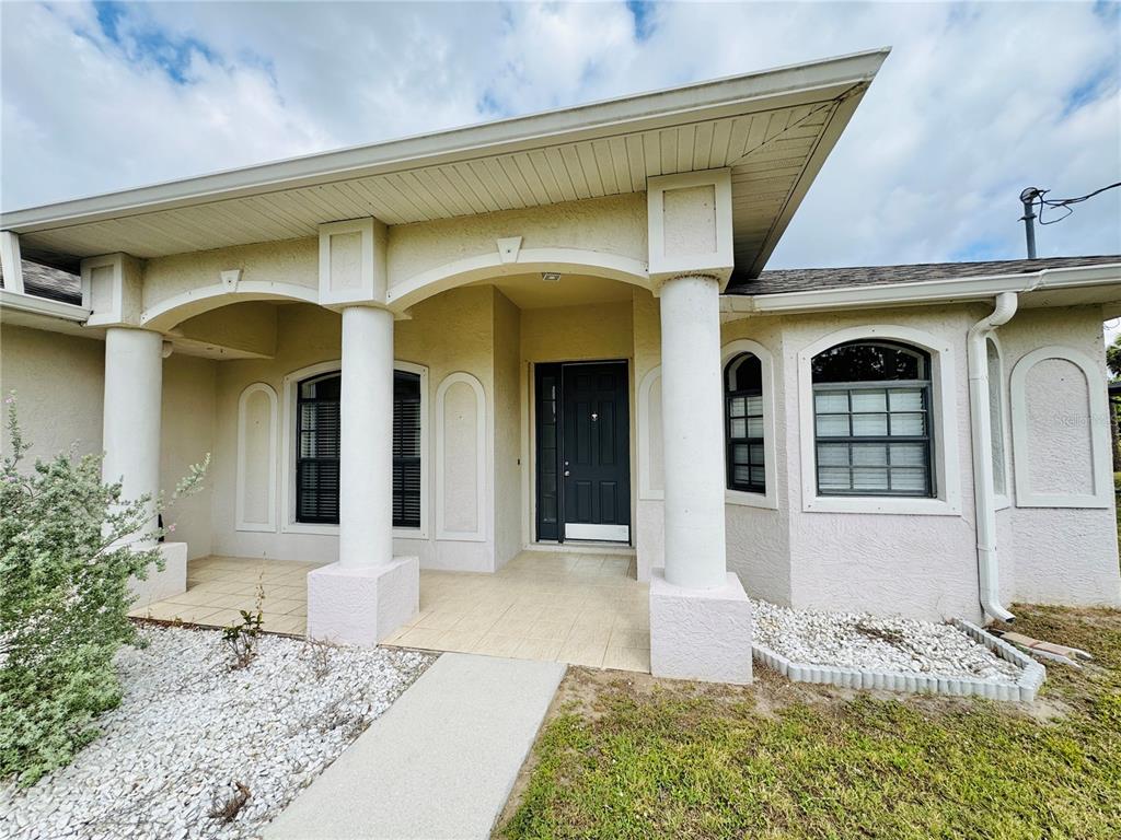 The exterior of a house features a covered entryway with white columns and a dark door — 3309 N CRANBERRY BOULEVARD, NORTH PORT, FL
