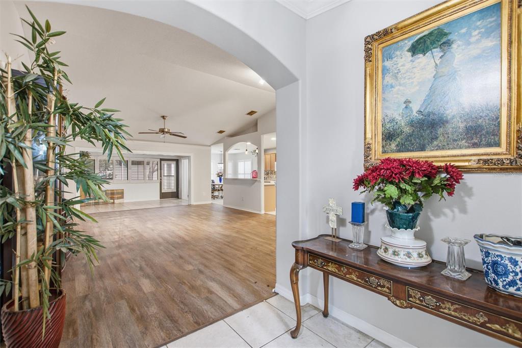 An entryway with a console table leads into a large living area with wood flooring — 16416 SW 15TH COURT, OCALA, FL