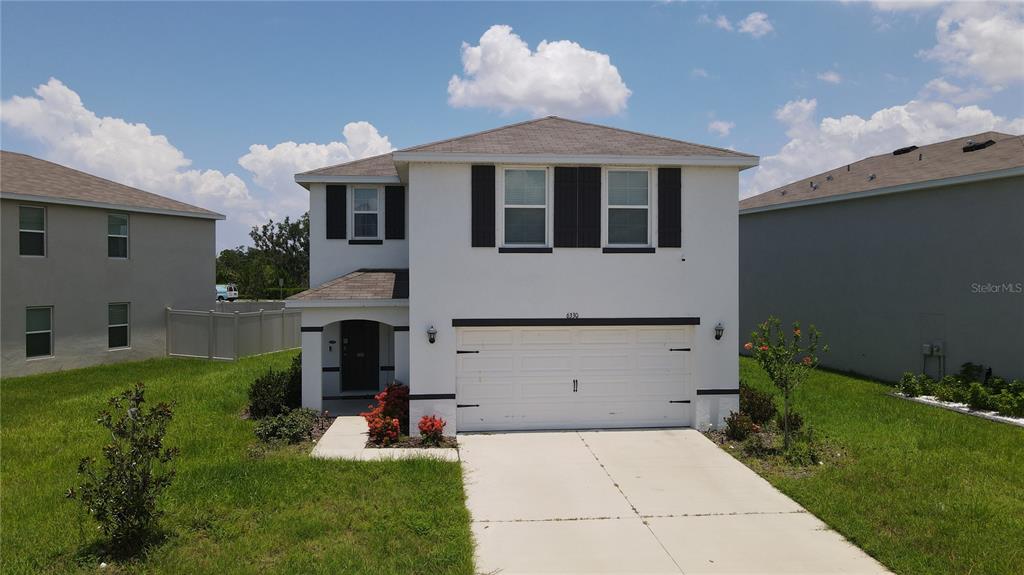 A two-story house with a white stucco exterior, a two-car garage, and a concrete driveway — 6330 DISTANT HAZE PLACE, PALMETTO, FL