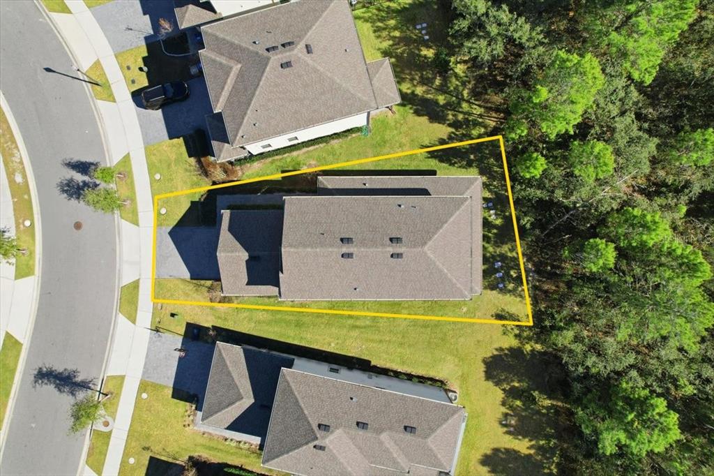 An aerial view shows a house with a highlighted property boundary line on a lot — 7792 SOMERSWORTH DRIVE, KISSIMMEE, FL