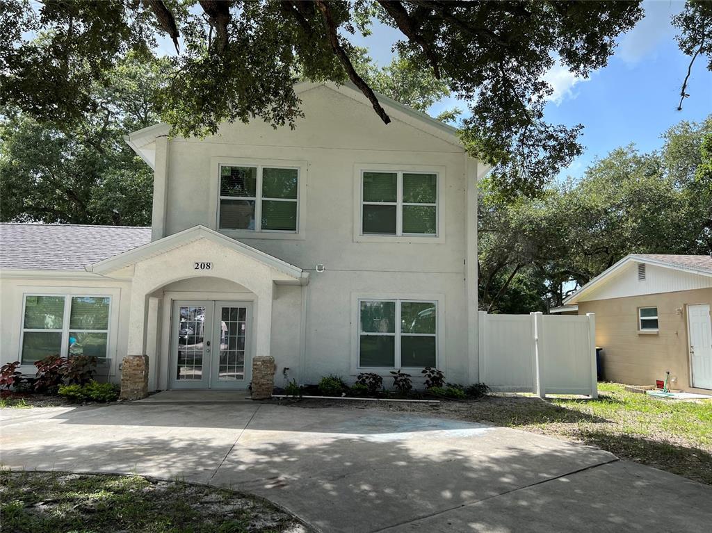 A two-story white stucco building features a covered entryway and a concrete driveway — 208-210-212 ELIZABETH AVENUE UNIT A,B, CLEARWATER, FL