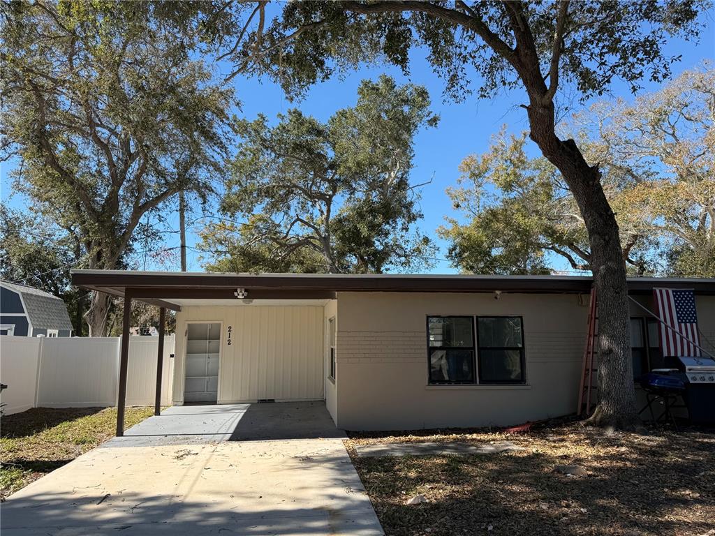 A single-story house with a carport, a concrete driveway, and a large tree in front — 208-210-212 ELIZABETH AVENUE UNIT A,B, CLEARWATER, FL