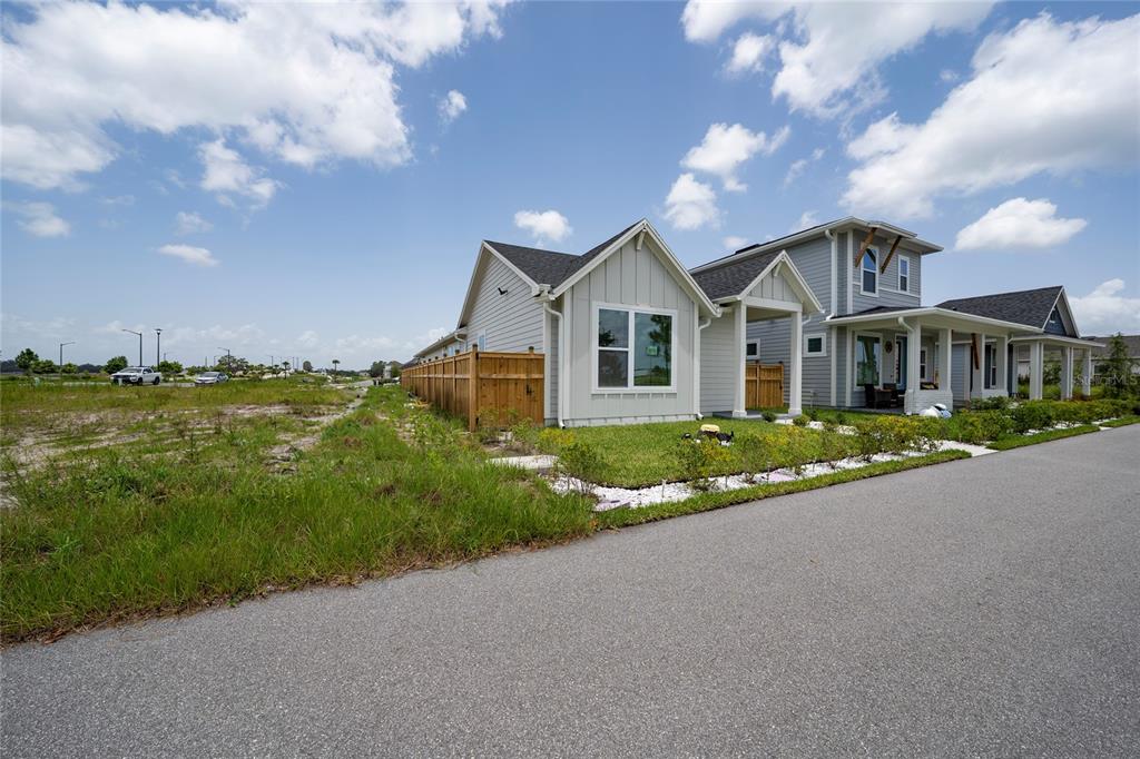 A side view of a modern house with light siding and a wooden fence — 2914 SAILHOUSE DRIVE, ST CLOUD, FL