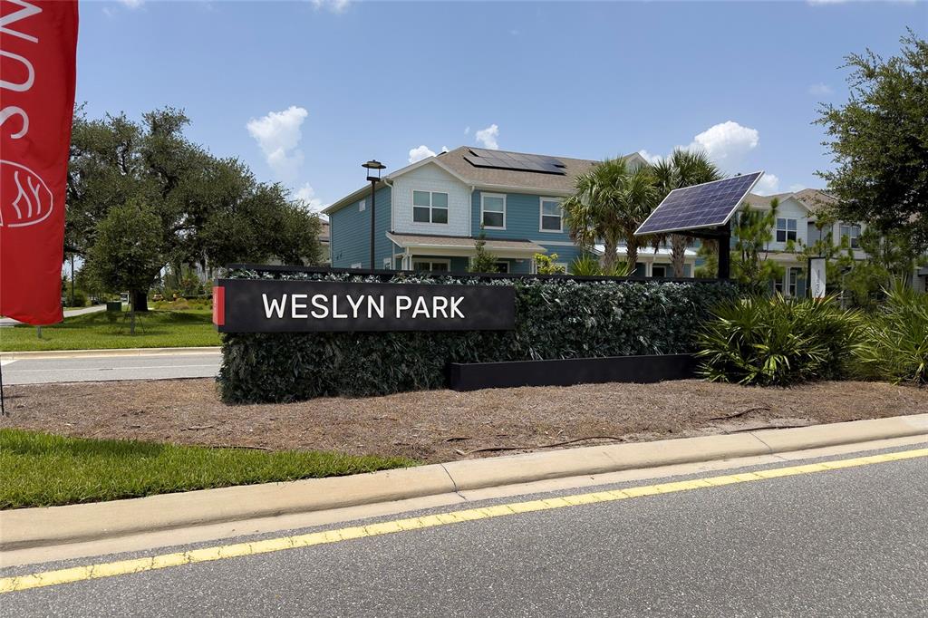 A black Weslyn Park community sign stands in front of a multi-story residential building — 2914 SAILHOUSE DRIVE, ST CLOUD, FL