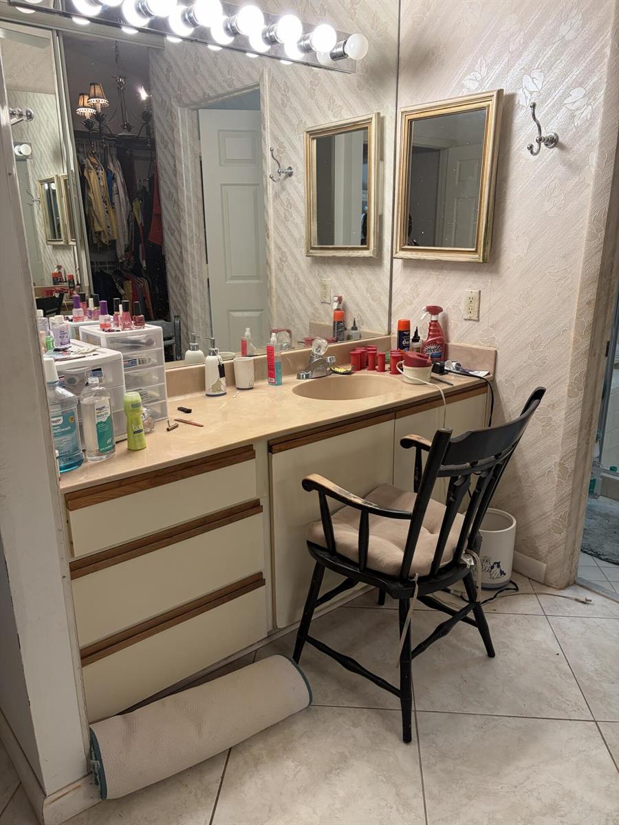 A bathroom vanity features a beige countertop, dual mirrors, and a black wooden chair — 4807 Boxwood Circle, Boynton Beach FL 33436, BOYNTON BEACH, FL