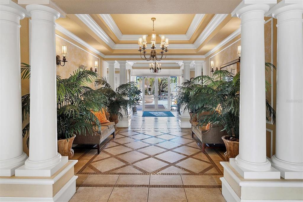A grand lobby features white columns, tile flooring, potted palms, and a central chandelier — 1064 N TAMIAMI TRAIL UNIT 1527, SARASOTA, FL