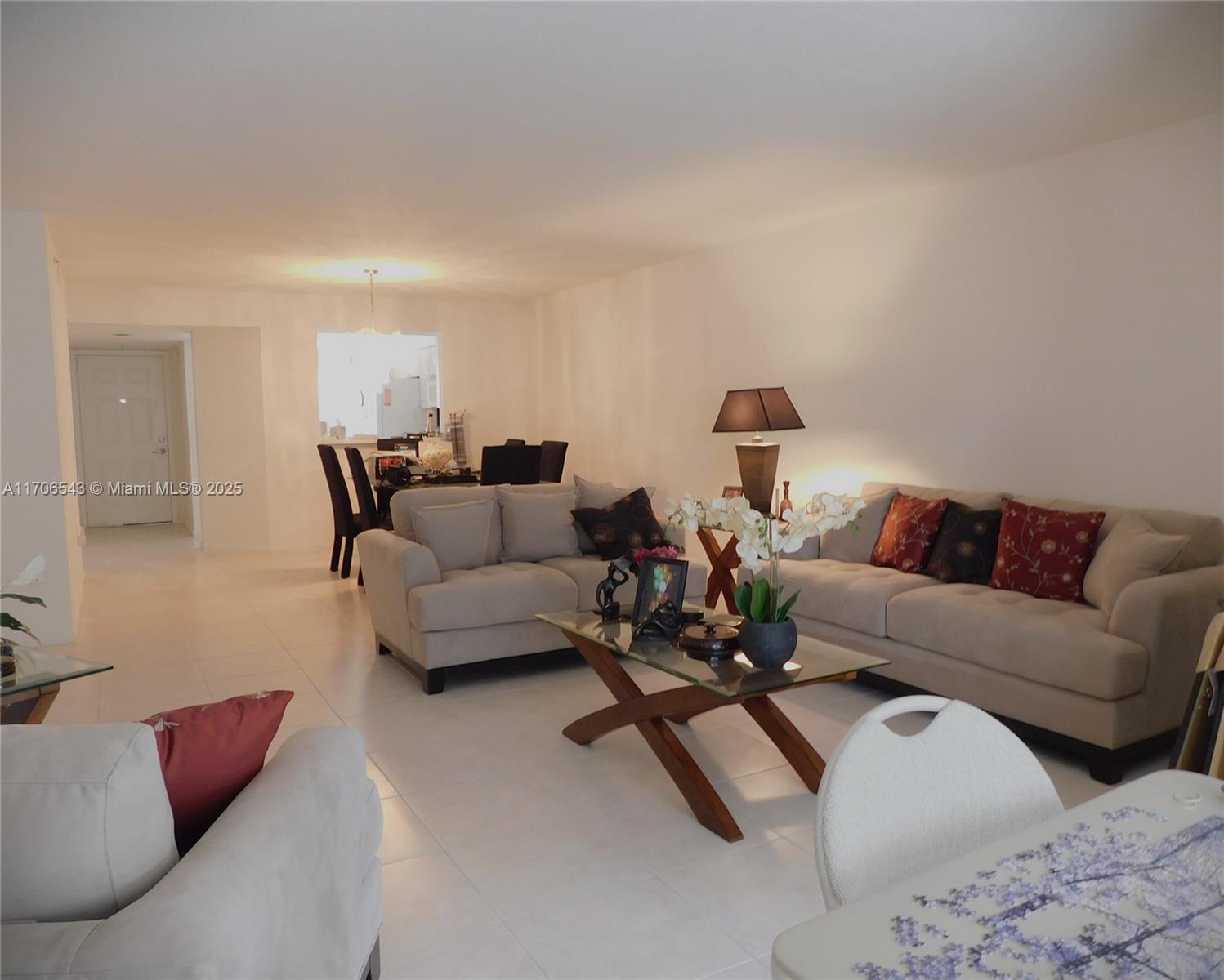 A living room with light-colored tile floors, beige sofas, and a glass-topped coffee table — 5749 Gemstone Ct # 307, Boynton Beach FL 33437, BOYNTON BEACH, FL