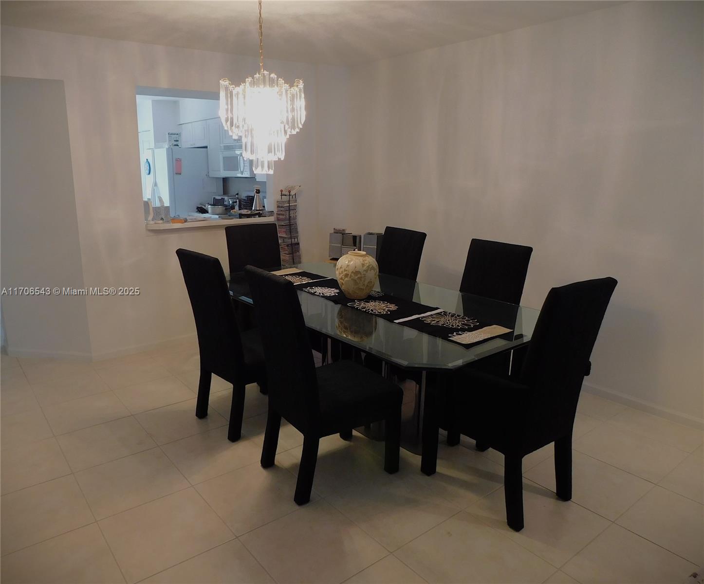A dining room features a glass table with six black chairs and a crystal chandelier — 5749 Gemstone Ct # 307, Boynton Beach FL 33437, BOYNTON BEACH, FL