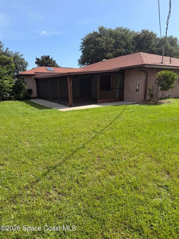 The exterior of a house features a large screened-in porch and a red shingled roof — 3079 SEA GATE CIRCLE, MERRITT ISLAND, FL