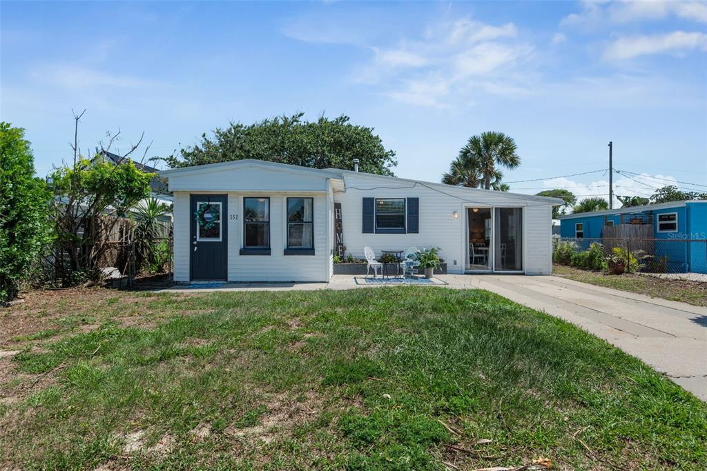 A single-story white house with a dark front door and a concrete driveway — 151 HOLLAND ROAD, ORMOND BEACH, FL