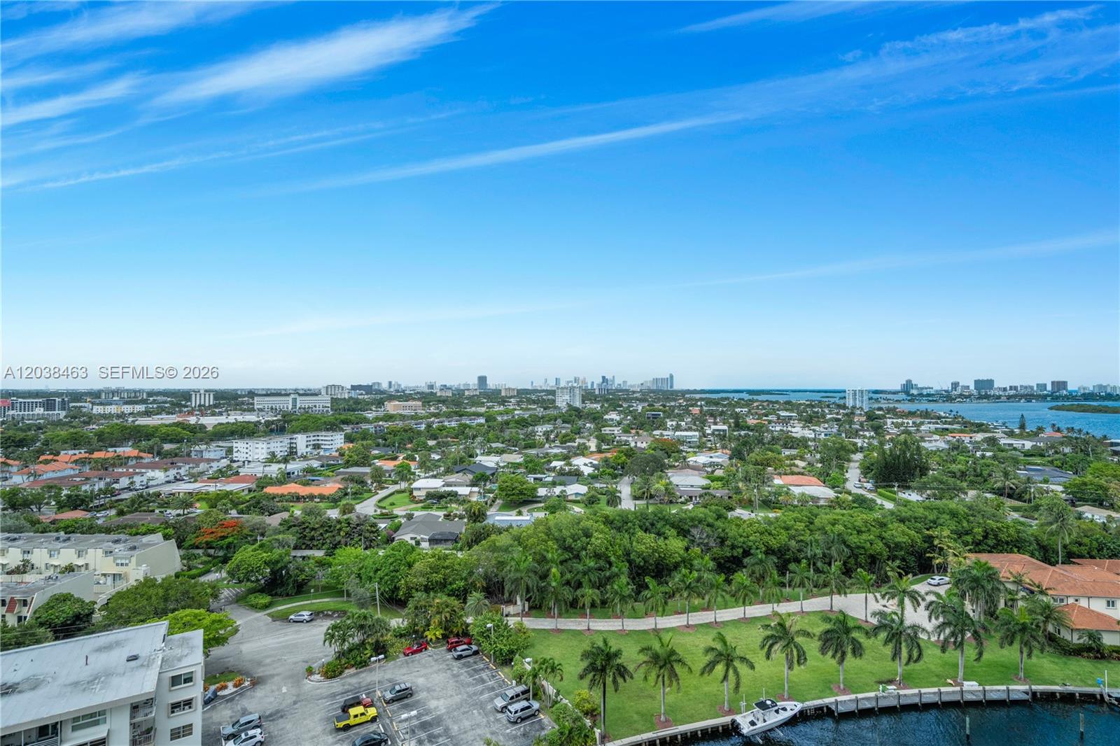 An aerial view shows a suburban neighborhood with palm trees, a parking lot, and a canal — 1800 NE 114th St # 1811, Miami FL 33181, MIAMI, FL