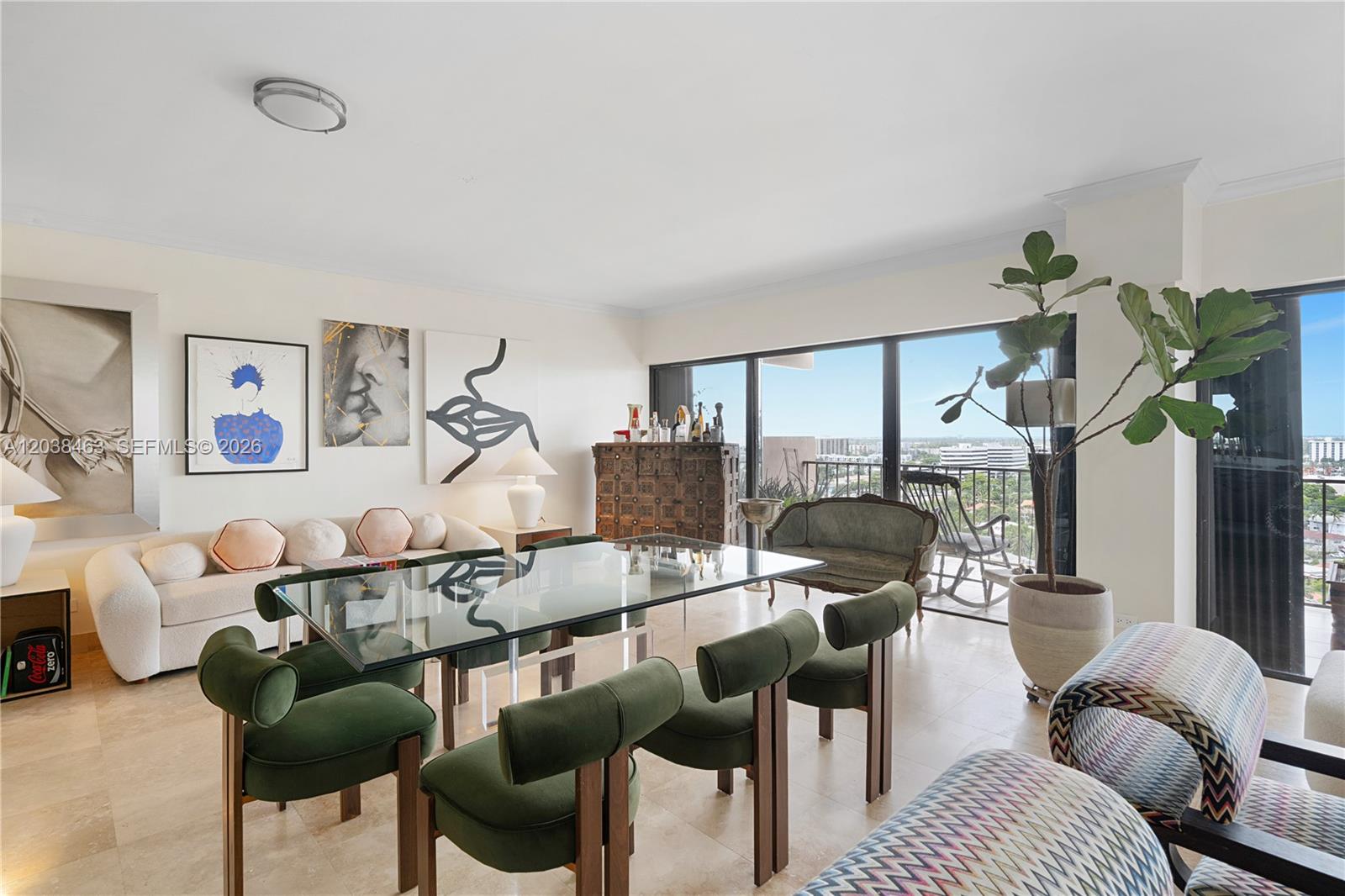 A dining area features a glass table, green chairs, and a balcony with city views — 1800 NE 114th St # 1811, Miami FL 33181, MIAMI, FL