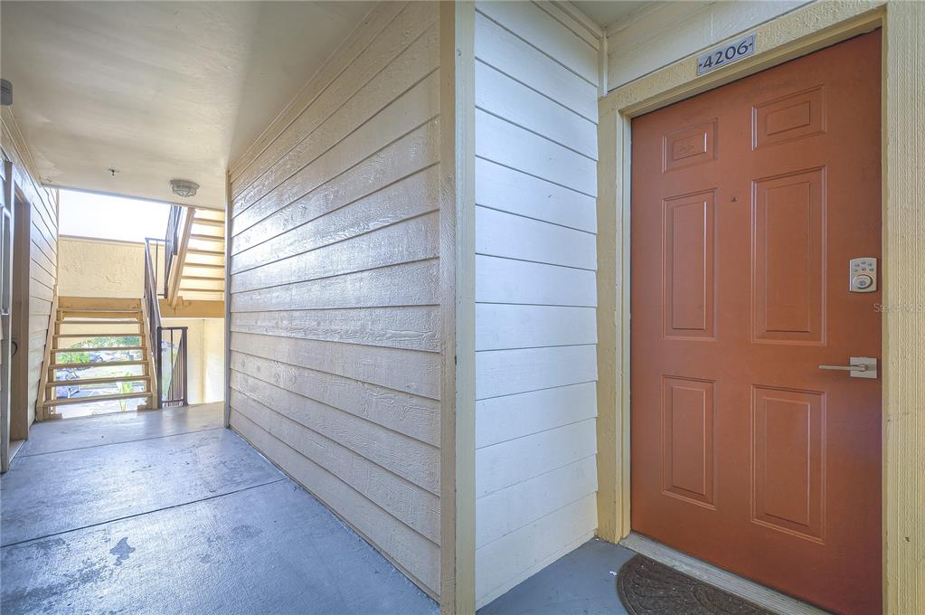 An exterior view of an apartment entrance with a brown door labeled 4206 — 11901 4TH STREET N UNIT 4206, ST PETERSBURG, FL