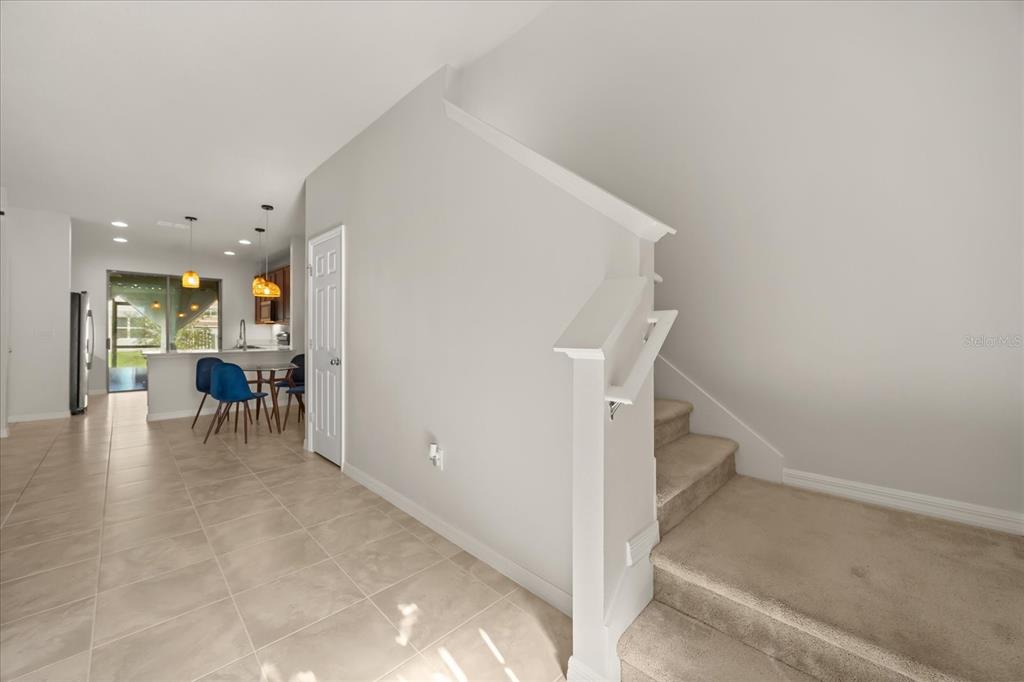 A tiled entryway leads to a kitchen with a dining area and carpeted stairs — 2716 VISTA VERDE LANE, KISSIMMEE, FL