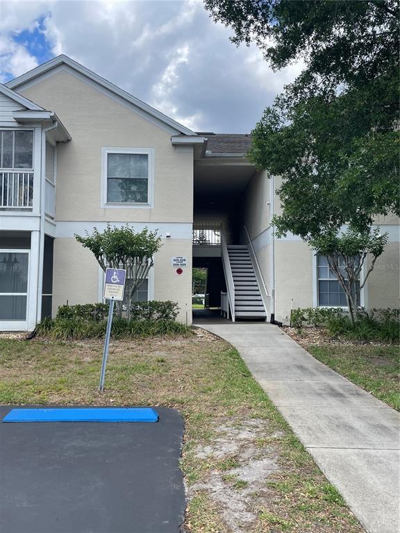 An exterior view of a two-story apartment building with a central staircase and sidewalk — 3960 SOUTHPOINTE DRIVE UNIT 507, ORLANDO, FL