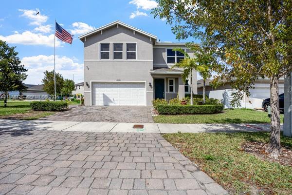 A two-story gray house with a two-car garage and an American flag in front — 13235 SW 270th Ter, Homestead FL 33032, HOMESTEAD, FL