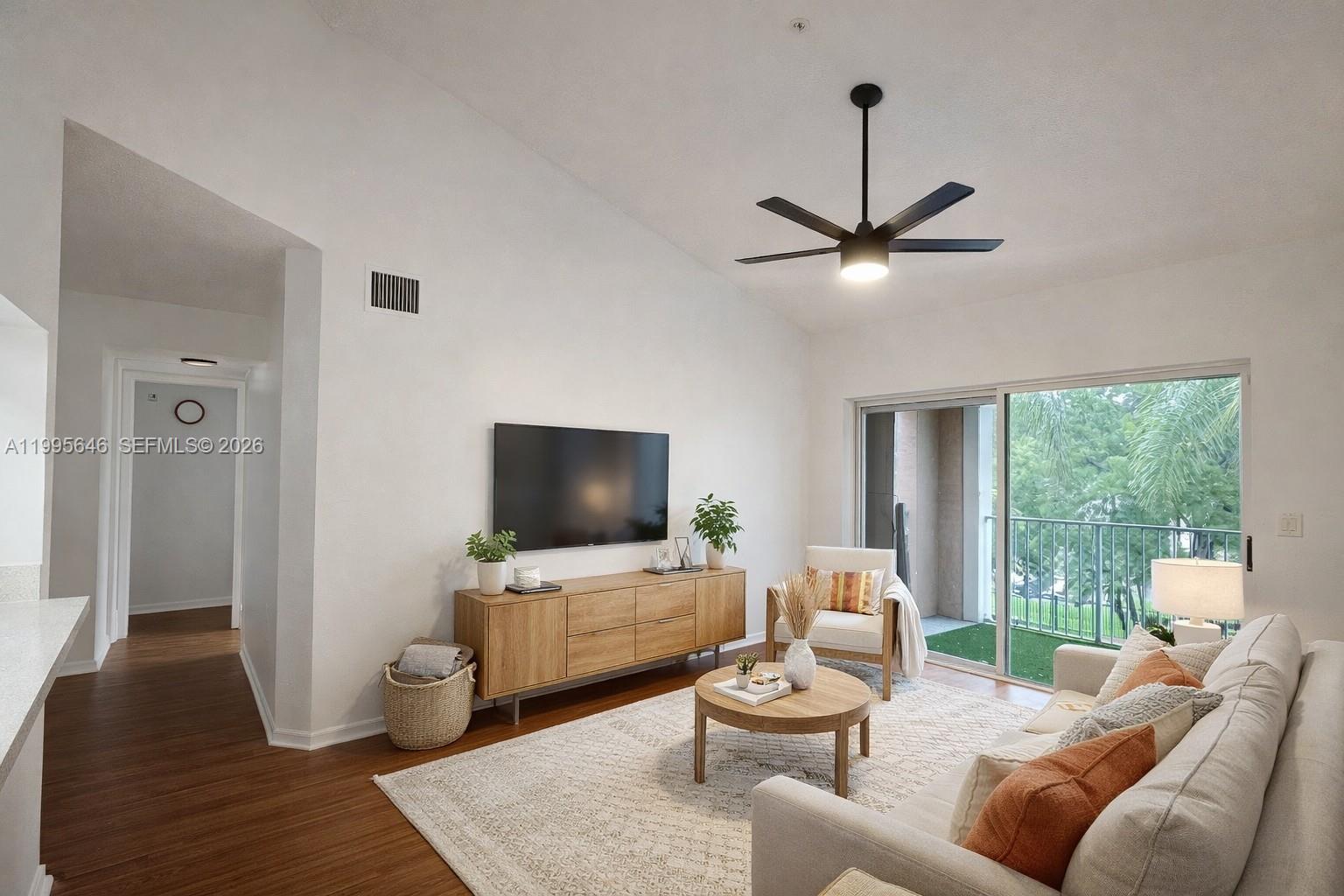 A living room features a light-colored sofa, wooden media console, and a ceiling fan — 12124 Saint Andrews Pl # 305, Miramar FL 33025, MIRAMAR, FL