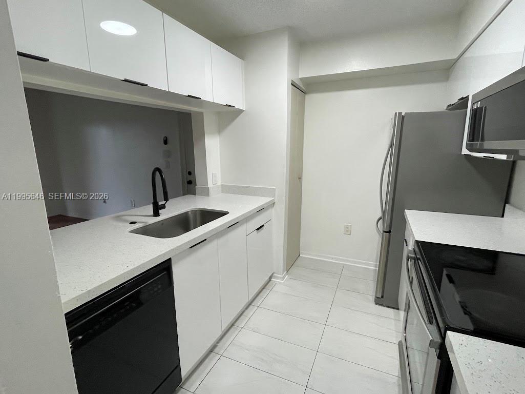 A kitchen features white cabinets, stainless steel appliances, and light-colored countertops — 12124 Saint Andrews Pl # 305, Miramar FL 33025, MIRAMAR, FL