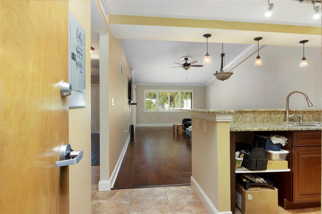 A view from a doorway into a kitchen with granite counters and a living area — 2595 COUNTRYSIDE BOULEVARD UNIT 8311, CLEARWATER, FL