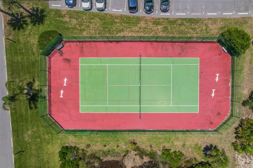 An aerial view shows a fenced tennis court with a red perimeter and green interior — 1003 OCEAN MARINA DRIVE UNIT 1003, FLAGLER BEACH, FL