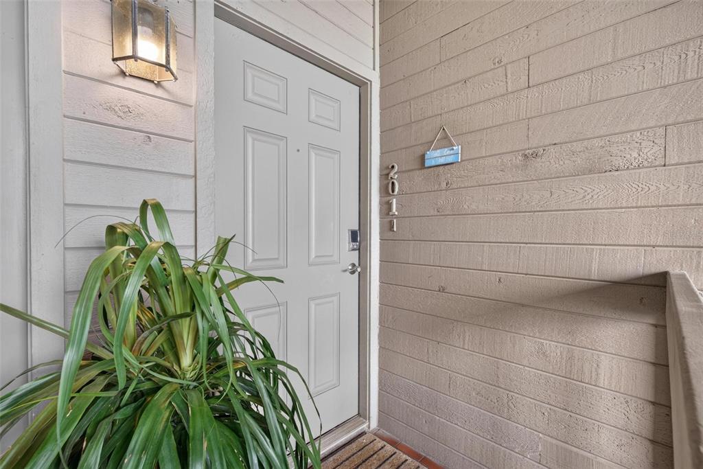 A light-colored front door with a house number and a potted plant on a porch — 300 BEACH TRAIL UNIT 201, INDIAN ROCKS BEACH, FL