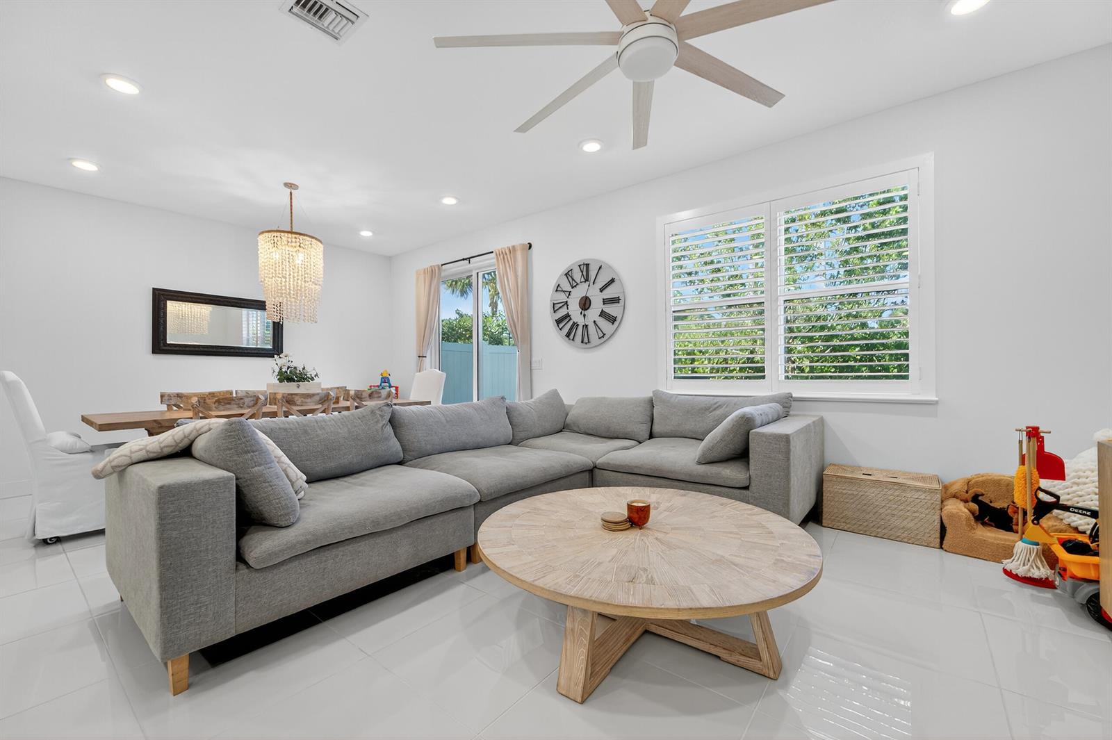 A living room features a grey sectional sofa, a round wooden coffee table, and white tile — 205 Preserve Trail S # 602, Stuart FL 34994, STUART, FL