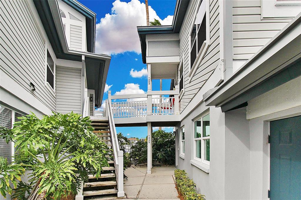 An exterior view shows a walkway connecting two buildings with stairs leading to the upper level — 1343 SIESTA BAYSIDE DRIVE UNIT 1343-C, SARASOTA, FL