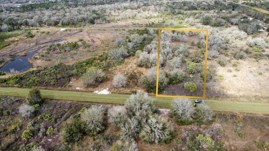 An aerial view shows a rectangular lot outlined in yellow amidst a rural, wooded landscape — 20167 NW 264th Street, Okeechobee FL 34972, OKEECHOBEE, FL