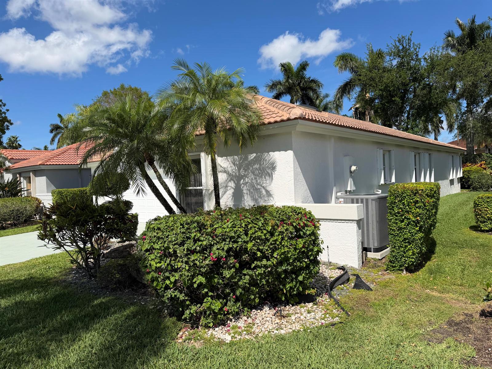 A white house with a tile roof, palm trees, and landscaping under a blue sky — 9706 Harbour Lake Circle, Boynton Beach FL 33437, BOYNTON BEACH, FL