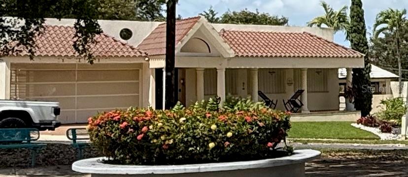 A single-story house with a tiled roof, a garage, and a landscaped circular garden bed — BF16 65 HILLS MANSIONS, SAN JUAN, PR