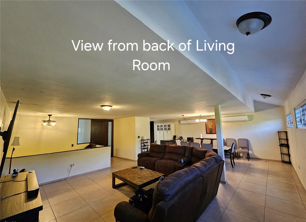 A spacious living room with tile flooring, a brown sectional sofa, and an open layout — BF16 65 HILLS MANSIONS, SAN JUAN, PR