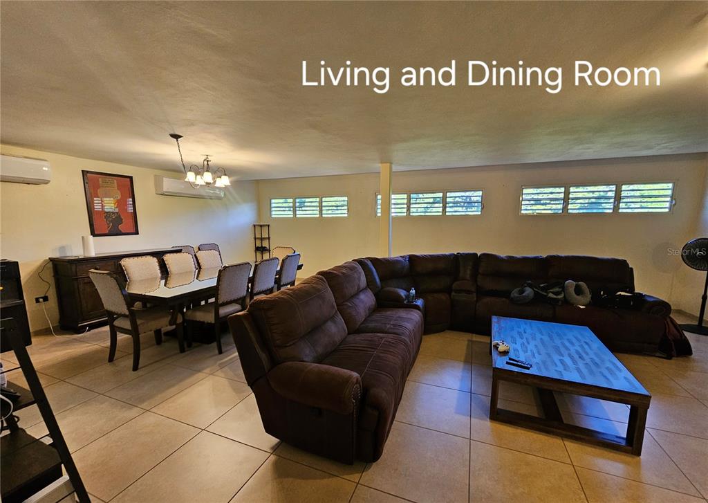 A living and dining room area features a large brown sectional sofa and dining set — BF16 65 HILLS MANSIONS, SAN JUAN, PR