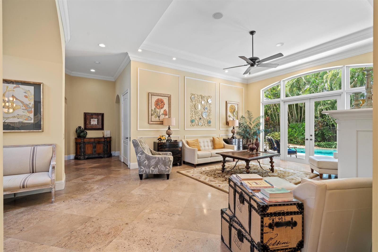 A spacious living room features tile floors, a coffered ceiling, and glass doors to a pool — 1232 Seaspray Avenue, Delray Beach FL 33483, DELRAY BEACH, FL