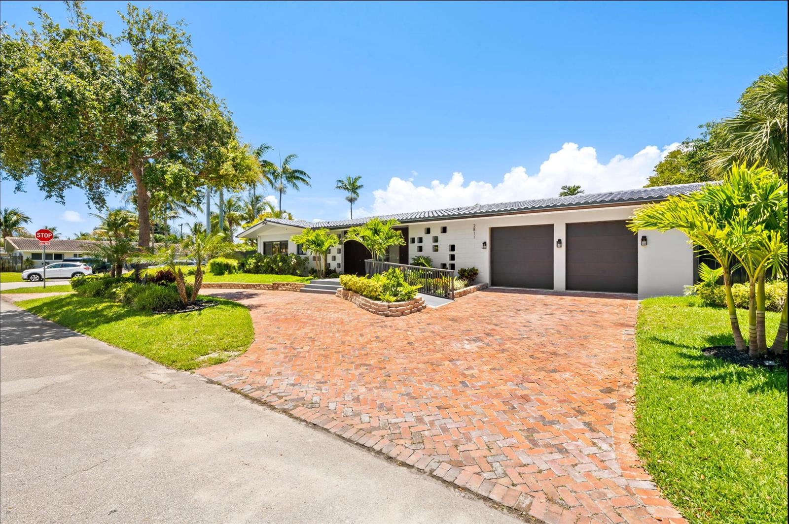 A single-story house with a brick driveway, two-car garage, and a ramp leading to the entrance — 2811 NE 53rd Court, Lighthouse Point FL 33064, LIGHTHOUSE POINT, FL