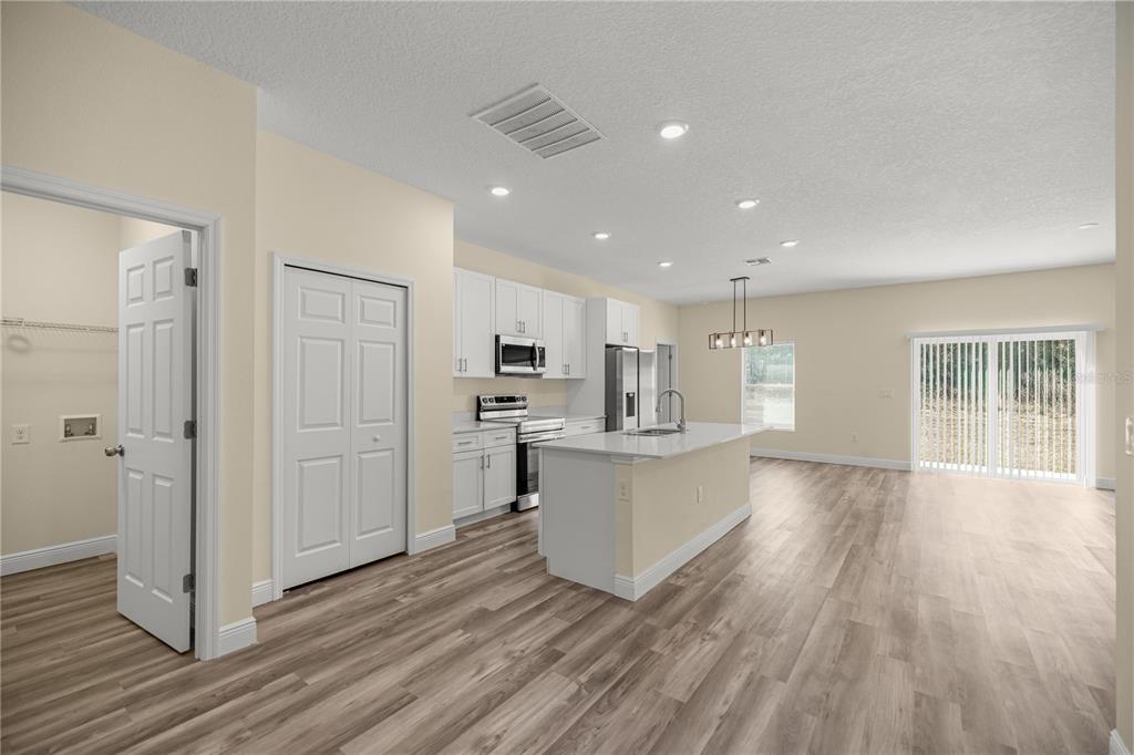 A single-story house with a beige stucco exterior, a two-car garage, and a dark roof — 13745 SW 43RD CIRCLE, OCALA, FL